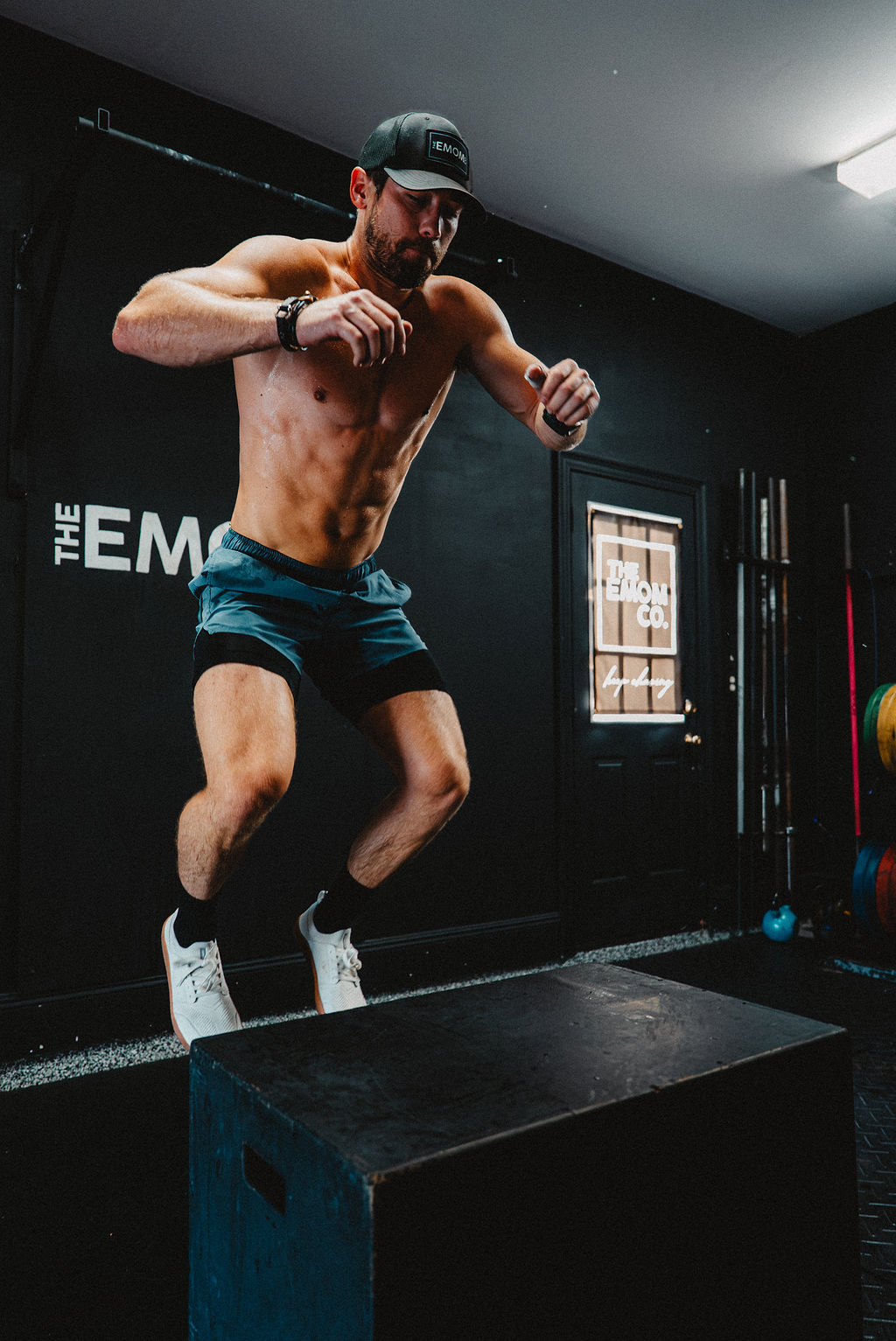 Athlete mid box jump during a conditioning workout at The EMOM Co.
